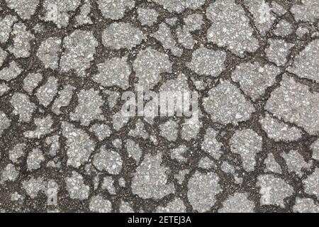 Close-up of cracked asphalt road surface Stock Photo
