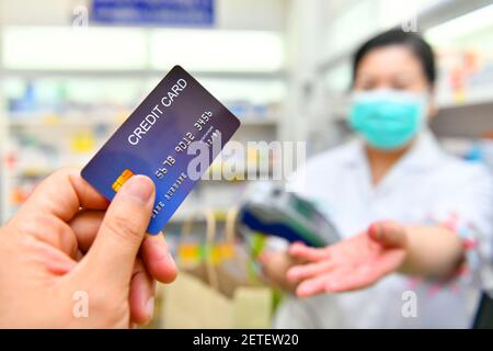 Man paying for Medicaments with credit card in pharmacy drugstore. Stock Photo