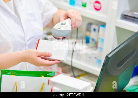 Pharmacist scanning medicine bottle with barcode scanner in pharmacy ...
