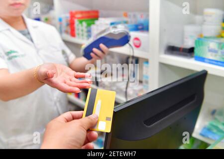 Man paying for Medicaments with credit card in pharmacy drugstore. Stock Photo