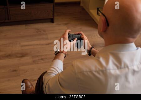 Gaming adult man holding simulator joypad. Person with keypad joystic in arms. Stock Photo