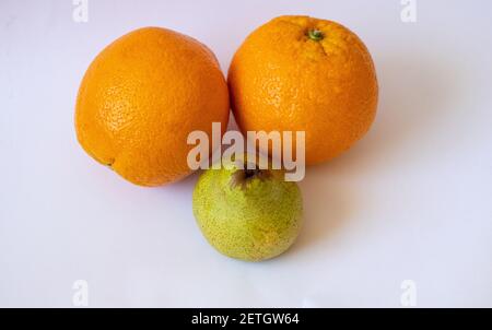 Two oranges and one pear on a white isolated background Stock Photo