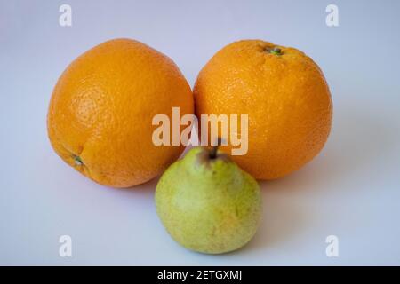 Two oranges and one pear on a white isolated background Stock Photo