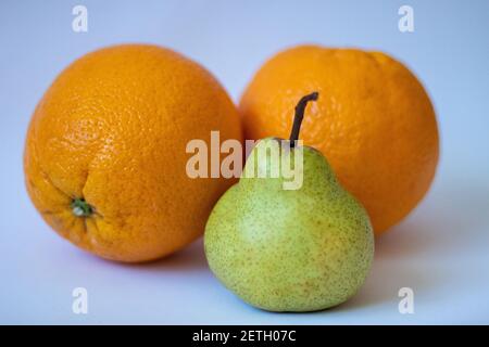 Two oranges and one pear on a white isolated background Stock Photo