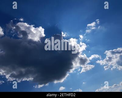 A ray of sun peeks through a dark cloud. Dark cloud in the sky. Sun from a cloud Stock Photo