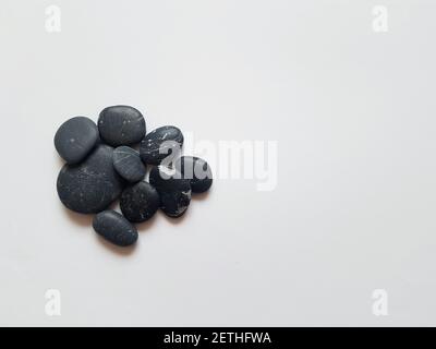 Black pebbles on white isolated background with mock up Stock Photo