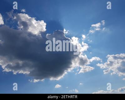 A ray of sun peeks through a dark cloud. Dark cloud in the sky. Sun from a cloud Stock Photo