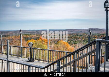 Viewpoint with Coin Binoculars of mesmerizing colorful atmospheric landscape with an autumn maple trees on the hills of the mountain ridge attract tou Stock Photo