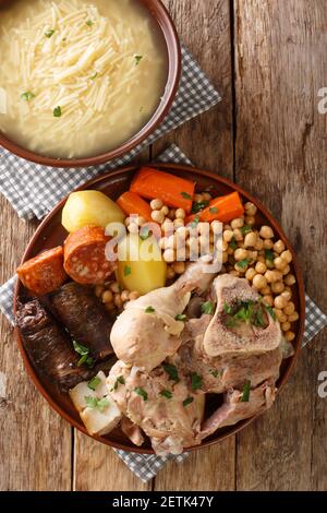 Cocido or cozido is a traditional stew eaten as a main dish in Spain, Portugal, Brazil close-up on a plate on the table. Vertical top view from above Stock Photo