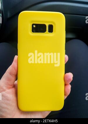 Yellow layout of the phone case. Smartphone in a yellow plastic case rear view Stock Photo