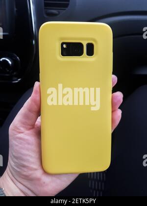 Yellow layout of the phone case. Smartphone in a yellow plastic case rear view Stock Photo