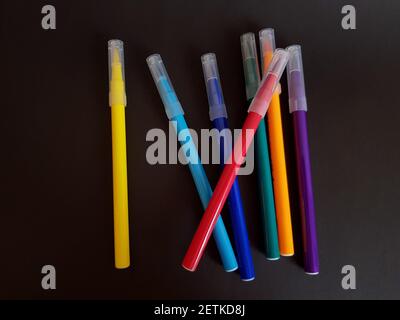 Multi-colored markers for drawing. Markers on a black isolated background Stock Photo