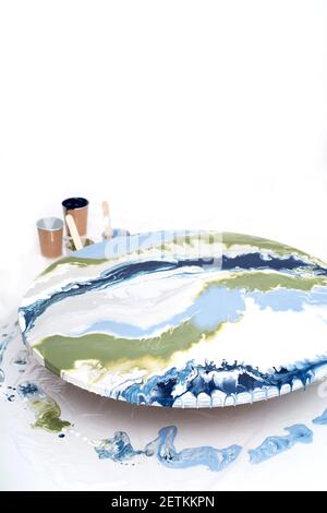 Artistic background. Round canvas with dripping paint. The process of creating a painting using fluid art technique. Stock Photo
