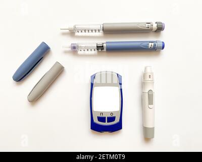 Insulin short, long, glucose meter, test strips and finger piercing pen on a white isolated background. Set for diabetics with mock up Stock Photo