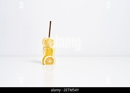 Lemonade concept. Yellow lemons and golden paper straw on white background Stock Photo