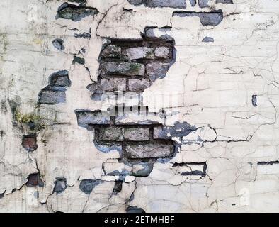 Background of a crumbling brick wall close-up. The texture of a crumbling wall Stock Photo