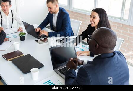 Young business people working and communicating while sitting at the office desk together with colleagues sitting. business meeting Stock Photo