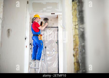 Skilled electrician using unimer for voltage checking Stock Photo