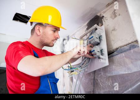 Applying automatic switches on distribution board with standard screwdriver Stock Photo