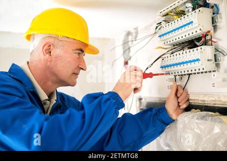 Experienced electrician doing electrical work with high precision and neatness Stock Photo