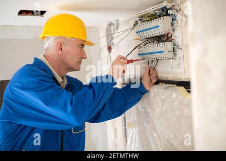Finishing touches of a skilled electrician and connecting of distribution board Stock Photo