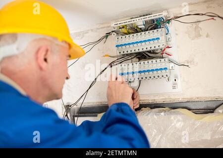 Finishing touches of a skilled electrician and connecting of distribution board Stock Photo