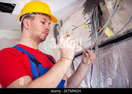 Handyman doing voltage checking with insulated screwdriver Stock Photo