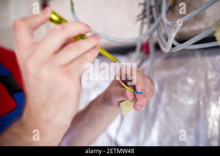 Handyman doing voltage checking with insulated screwdriver Stock Photo