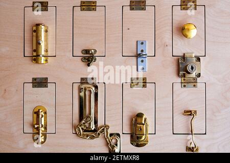 Many different locks on the wooden door. Stand with types of security systems Stock Photo