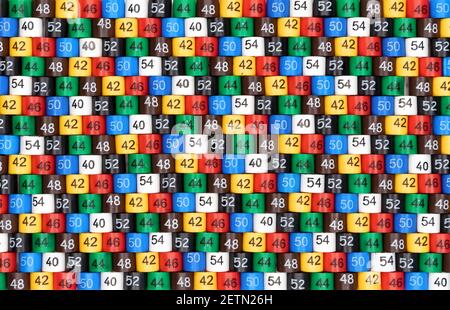 Background from multi-colored plastic tags of clothing sizes for a store. Stock Photo
