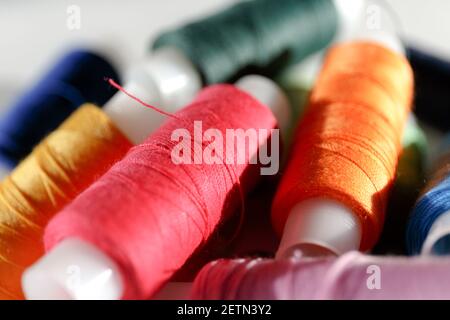 Color thread. Plastic reels with colorful threads close-up. Red and orange shades Stock Photo