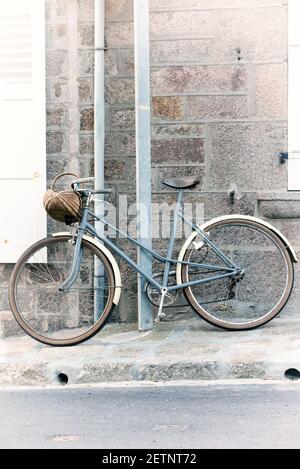 Old bicycle on a facade of house Stock Photo