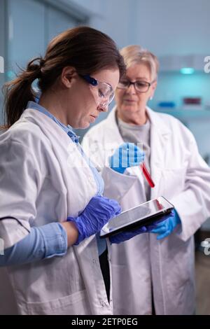 Doctors chemist researchers in white coat analysing blood test tube in equipped laboratory . Modern laboratory for scientific research with professional equipment for virus investigation working at vaccine development Stock Photo