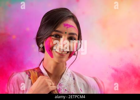 A YOUNG WOMAN POSING IN FRONT OF CAMERA DURING HOLI Stock Photo