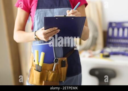 Woman repairman writing paper on clipboard closeup Stock Photo