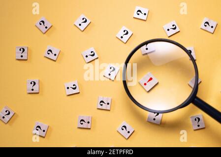 Magnifying glass focus on exclamation mark between question mark. Concept of Q&A, FAQ choice and solution Stock Photo