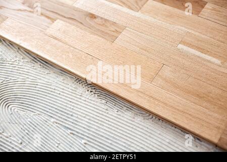 Process of a floor covering with parquet under way Stock Photo