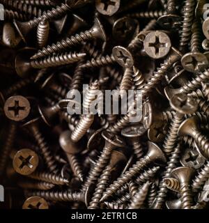 heap of new black self-tapping screws close-up Stock Photo