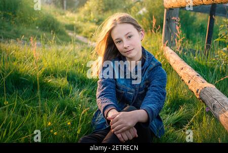 portrait of teenage girl with flowers in spring on green grass Stock Photo