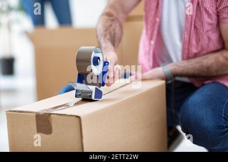 Packing things in boxes for moving at new apartment Stock Photo