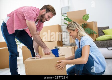 Young couple packing things in boxes for moving in new house Stock Photo