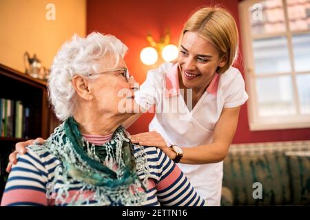 Smiling nurse with old senior woman patient at nursing home Stock Photo