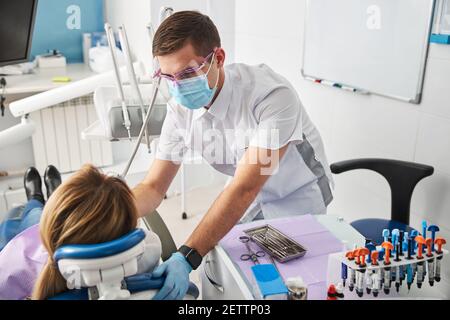 Cautious dentist performing a dental treatment on woman Stock Photo