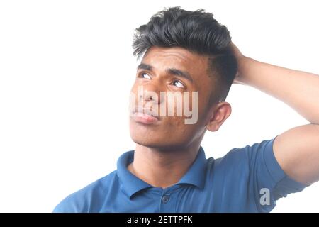 thoughtful young man hand over head looking away  Stock Photo