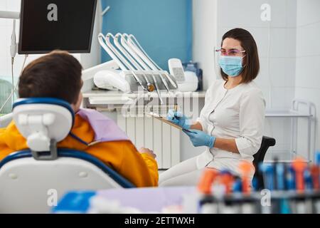Excited dental office doctor recording patient words to notepad Stock Photo