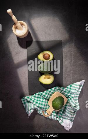 Avocados isolated on a white wooden background. Top view. Vertical format with copyspace. Stock Photo