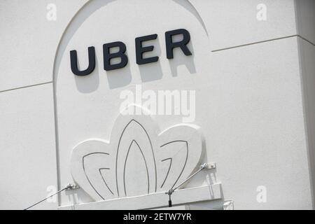 A logo sign outside of a Uber Technologies regional office in