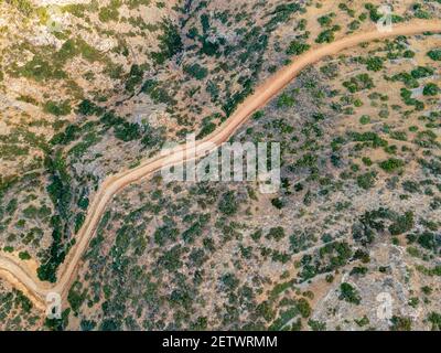 Aerial top view by drone of cretan landscape with road. Stock Photo