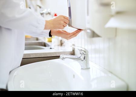 Close up view of a worker in sterile cloths washing hands a bathroom before working. Stock Photo
