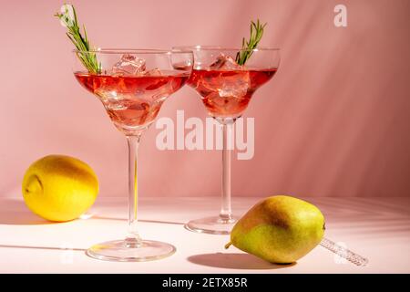 Refreshing cocktail in a glass with fruits on a bright background. Summer party concept. Stock Photo